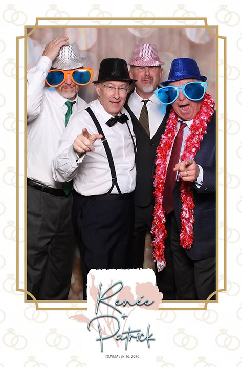 Four men in suits and fun props including oversized glasses, hats, and a red lei posing at a wedding photo booth. Frame reads 'Renée & Patrick, November 16, 2020.
