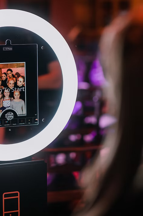 Close-up of a digital ring light photo booth with a touchscreen displaying event guests’ photos.