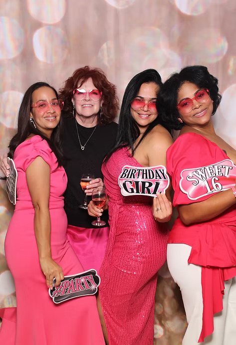 Friends posing with Sweet 16 birthday props at photo booth